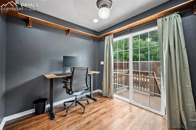 a view of a workspace with furniture and a window