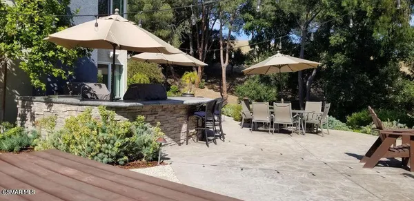 an outdoor space with lots of furniture and umbrella