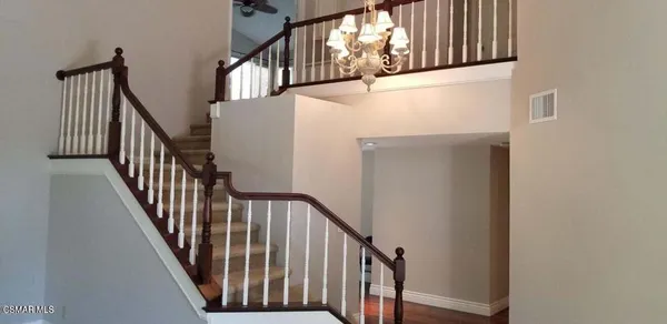a view of staircase with lots of frames on wall and windows