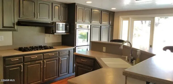a kitchen with stainless steel appliances granite countertop a stove a sink and a refrigerator