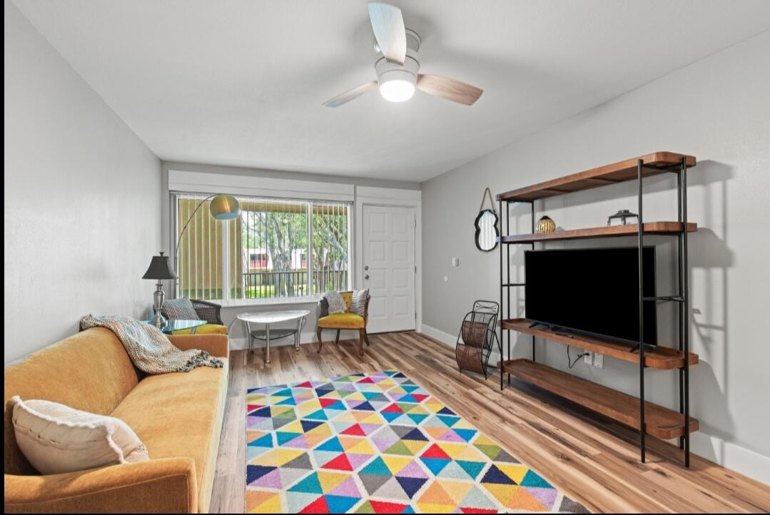 210 Pelham Road, Unit 211B Fort Walton Beach, FL 32547 - Photo 2 of 7 a living room with furniture and a flat screen tv