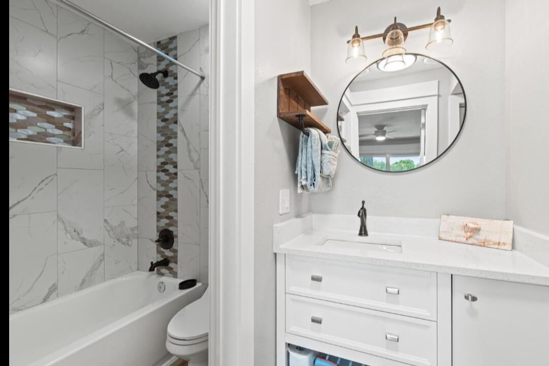 210 Pelham Road, Unit 211B Fort Walton Beach, FL 32547 - Photo 6 of 7 a bathroom with a sink a toilet and a mirror