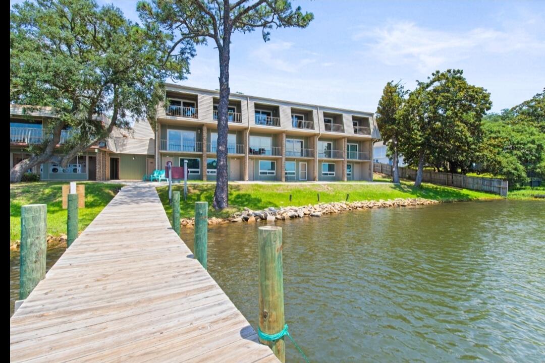 210 Pelham Road, Unit 211B Fort Walton Beach, FL 32547 - Photo 7 of 7 a view of a brick building next to a lake with a big yard