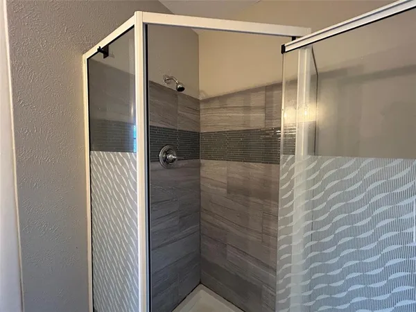 a bathroom with a shower and a glass door