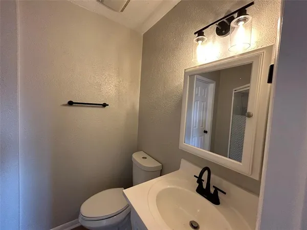 a bathroom with a sink a toilet and mirror