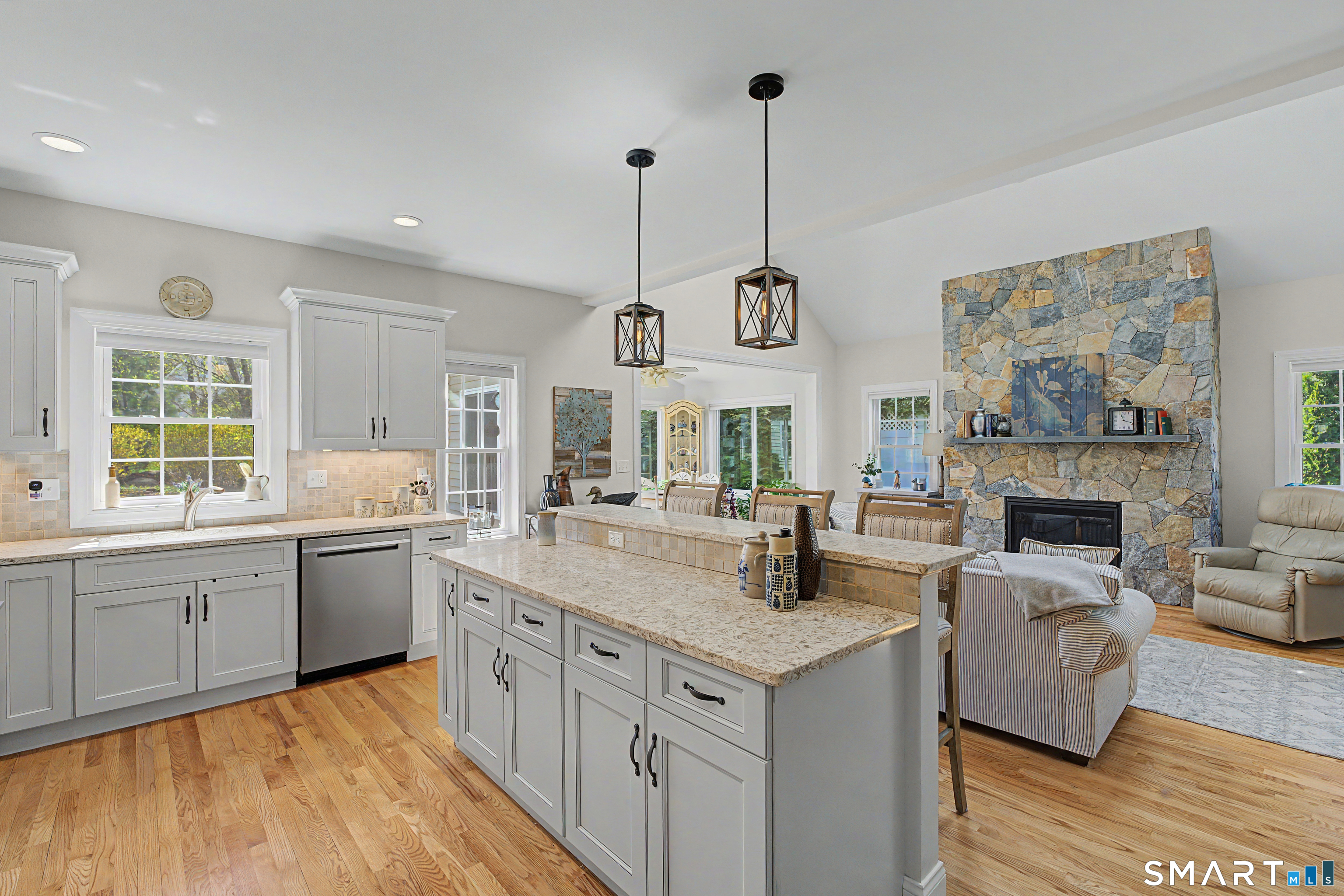 211 Meadowbrook Road, Unit 211 Oxford, CT 06478 - Photo 10 of 38 Spacious kitchen with oversized island, granite countertops, and stylish pendant lighting, open to the inviting family room with stone fireplace.