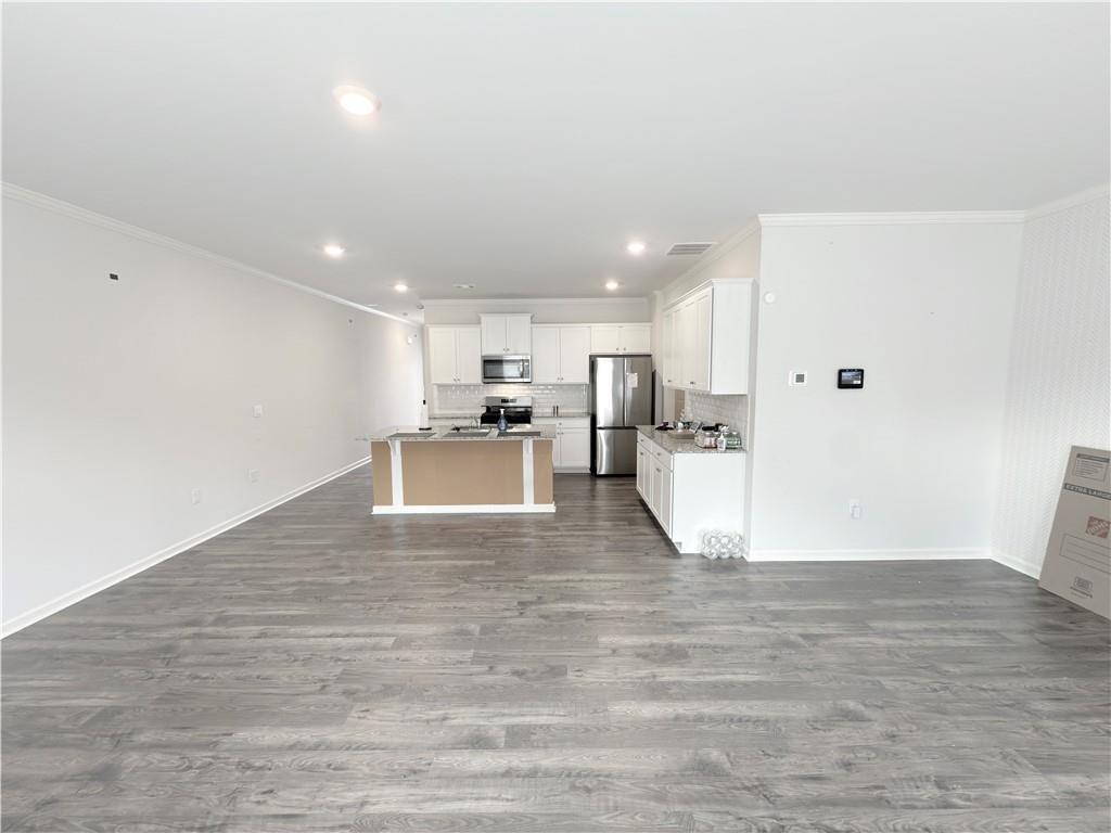 2715 Poppy Court Buford, GA 30519 - Photo 11 of 31 a view of kitchen with refrigerator microwave and wooden floor