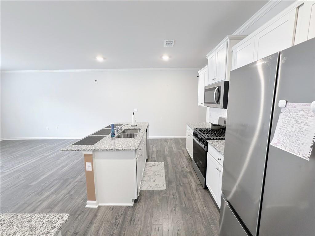 2715 Poppy Court Buford, GA 30519 - Photo 14 of 31 a kitchen with a sink a refrigerator and a stove top oven