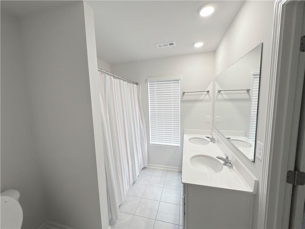 2715 Poppy Court Buford, GA 30519 - Photo 23 of 31 a bathroom with a sink a toilet and shower