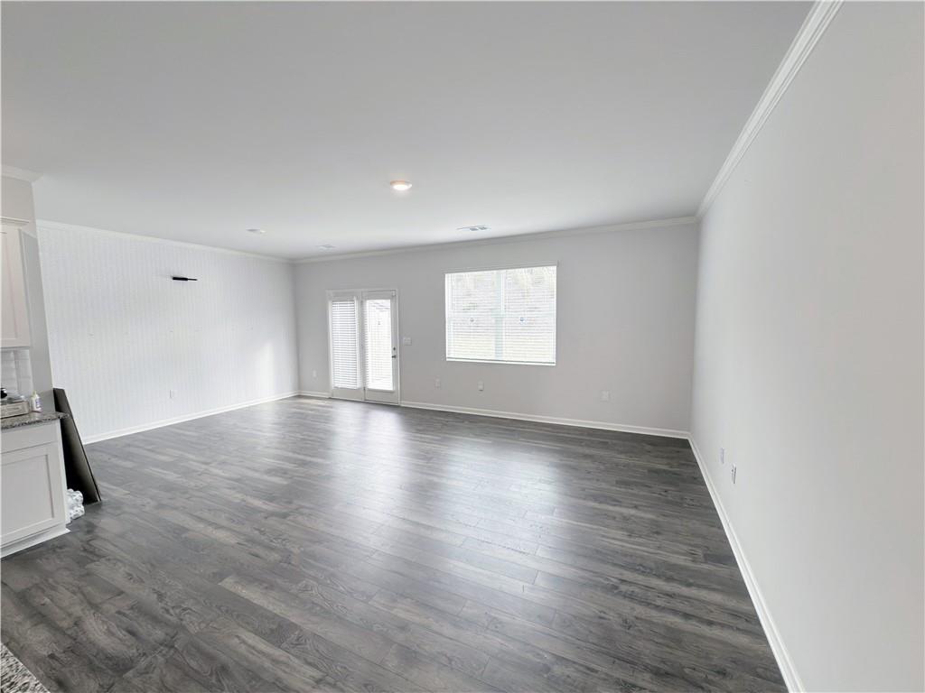 2715 Poppy Court Buford, GA 30519 - Photo 7 of 31 an empty room with wooden floor and windows