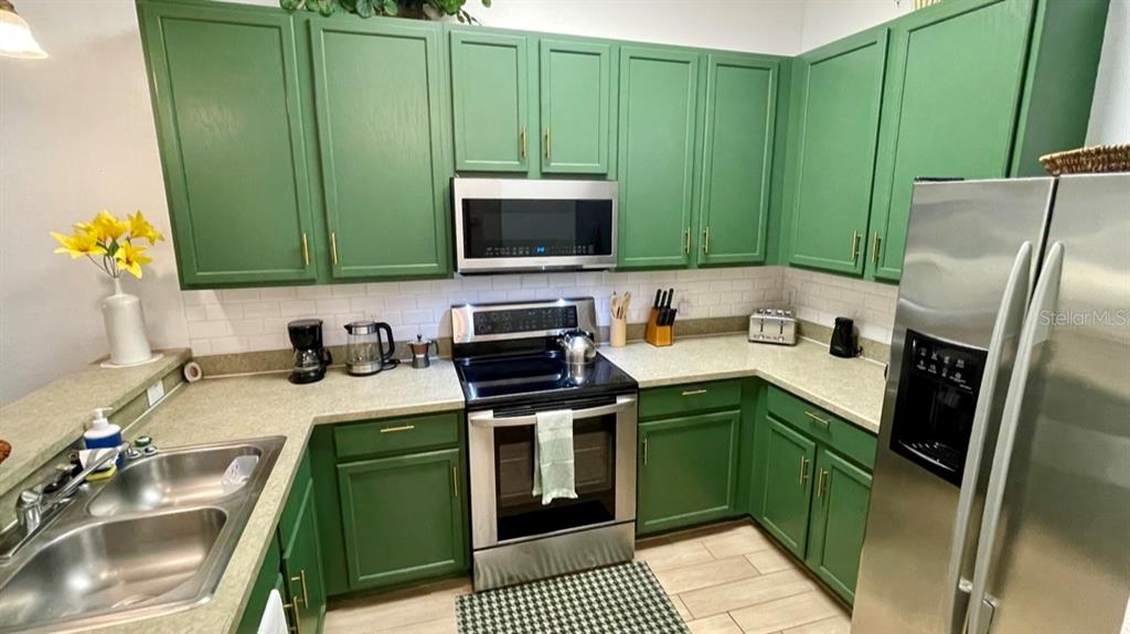202 Rum Run, Unit 36102 Davenport, FL 33897 - Photo 5 of 21 a kitchen with a sink a microwave and cabinets