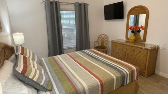 202 Rum Run, Unit 36102 Davenport, FL 33897 - Photo 9 of 21 a bedroom with a bed and a flat tv screen on dresser