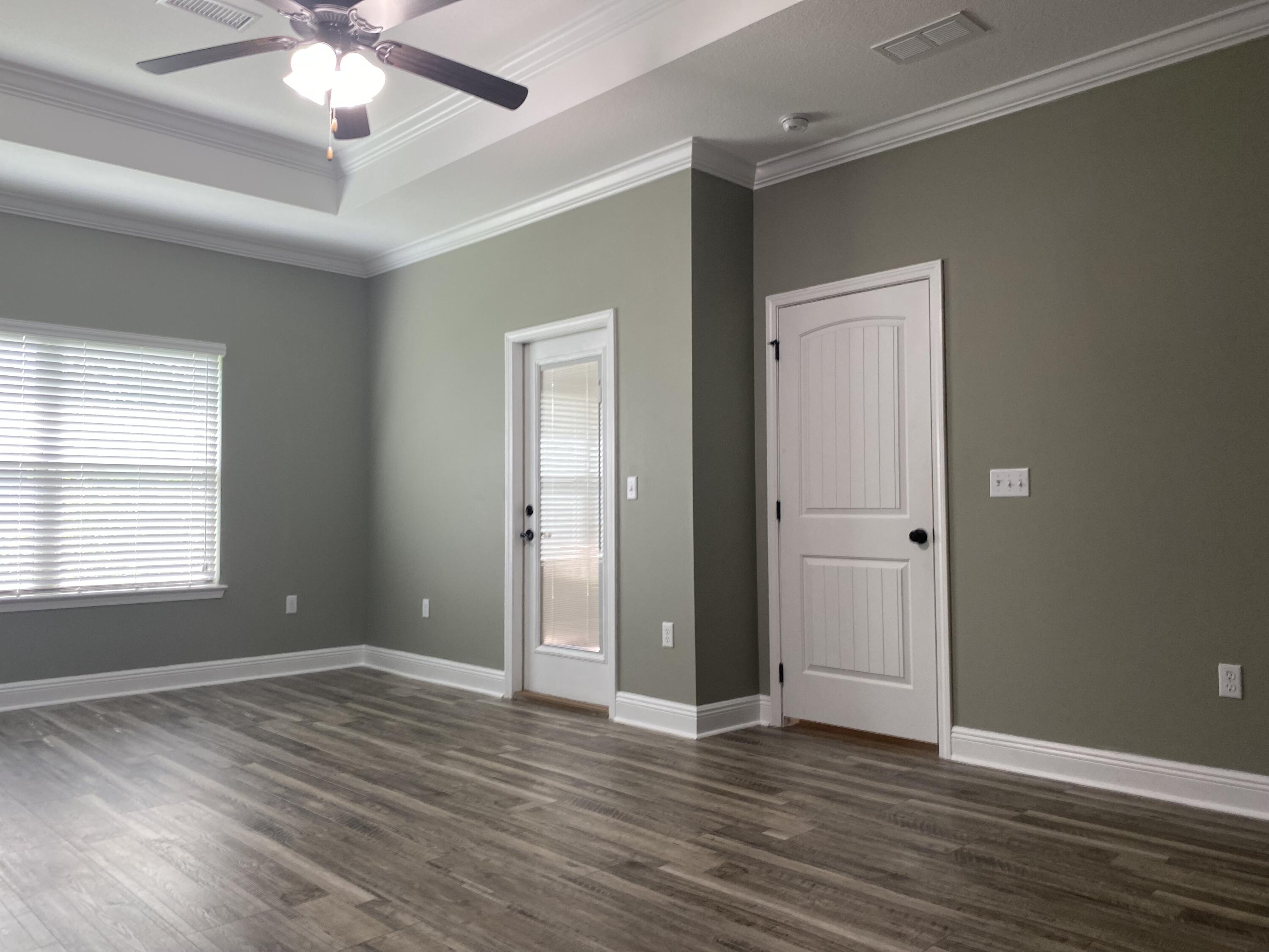 5870 Pescara Drive Pace, FL 32571 - Photo 17 of 31 a view of an empty room with wooden floor and a window