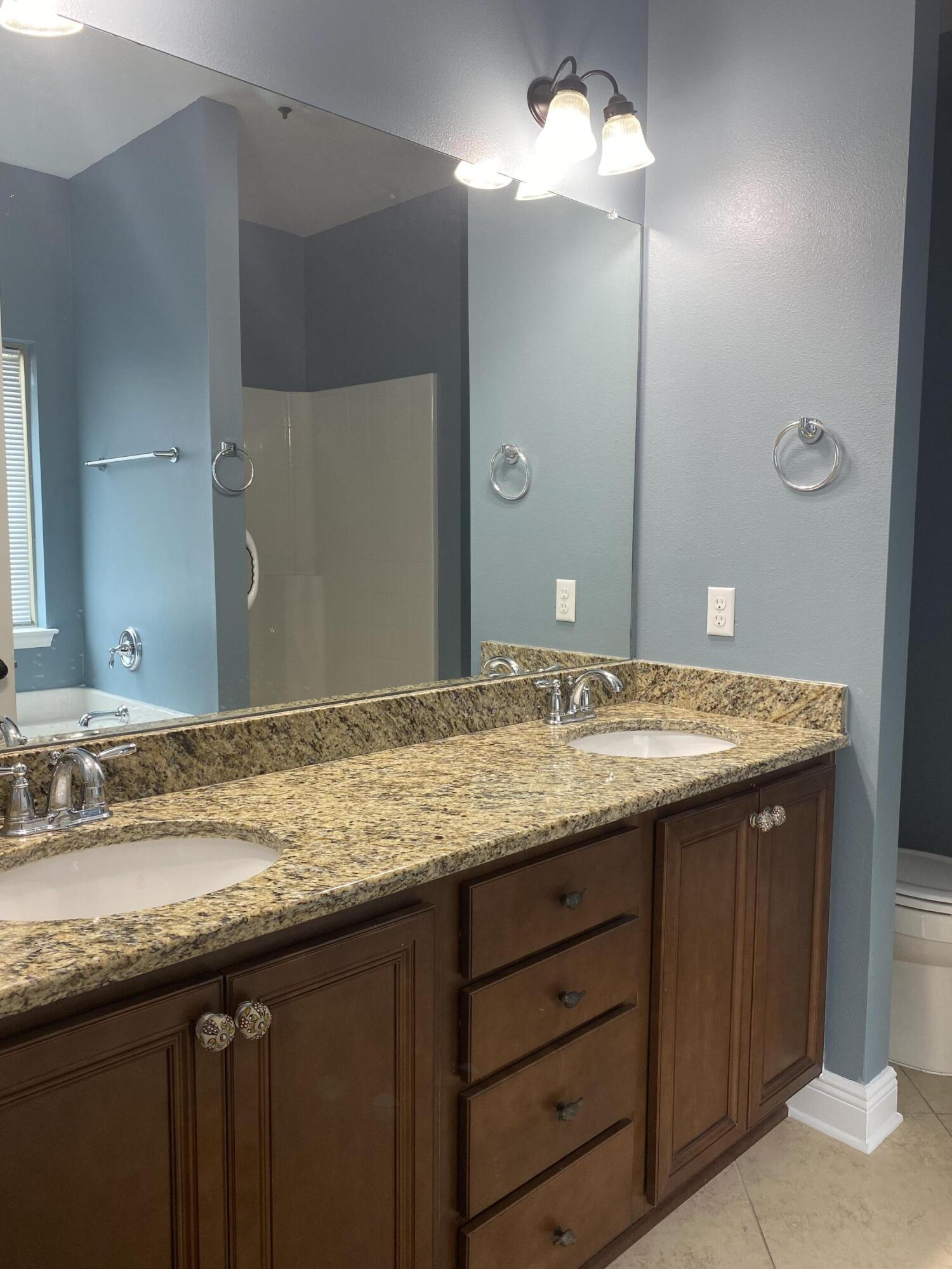 5870 Pescara Drive Pace, FL 32571 - Photo 19 of 31 a bathroom with a granite countertop sink and a mirror
