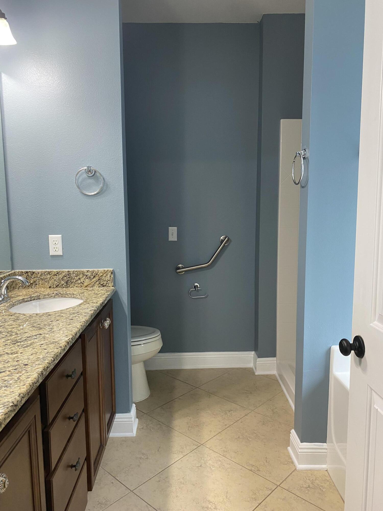 5870 Pescara Drive Pace, FL 32571 - Photo 20 of 31 a bathroom with a granite countertop sink and a toilet