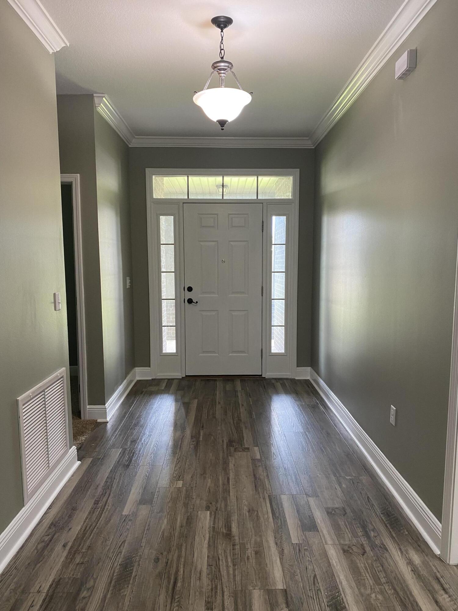 5870 Pescara Drive Pace, FL 32571 - Photo 6 of 31 an empty room with wooden floor and windows