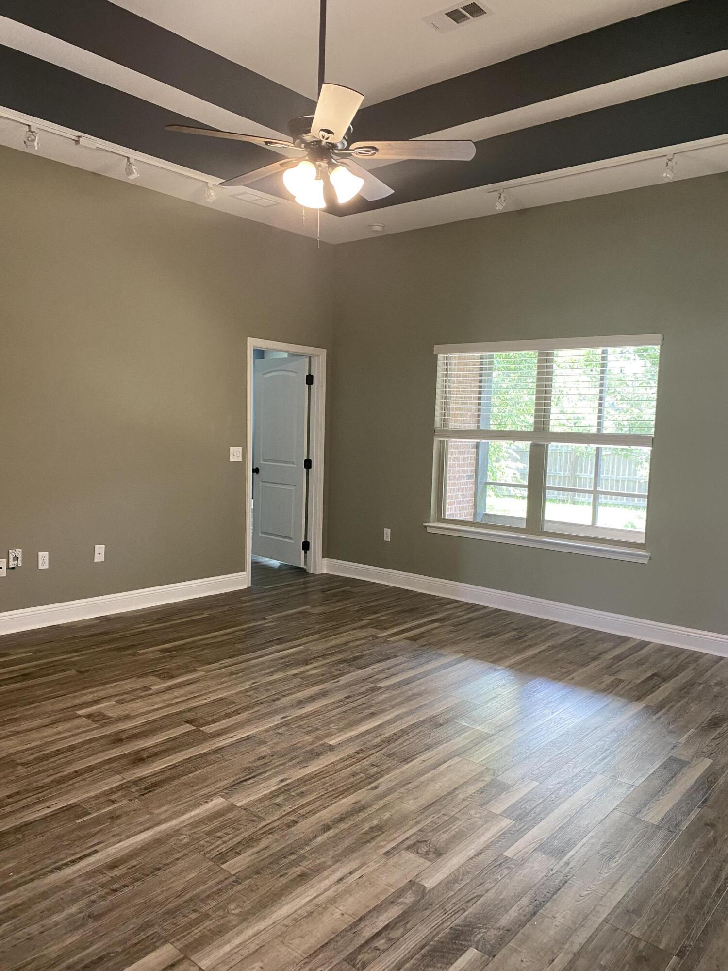 5870 Pescara Drive Pace, FL 32571 - Photo 9 of 31 a view of an empty room with wooden floor and a window