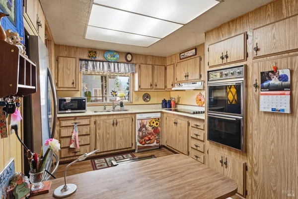 a kitchen with a refrigerator stove and white cabinets