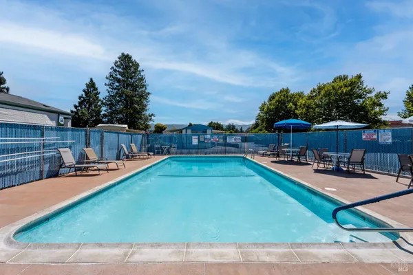 a view of a swimming pool with chairs in patio