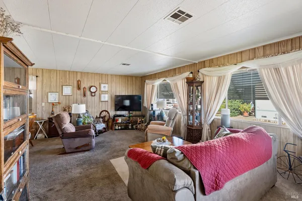 a living room with furniture a large window and a flat screen tv