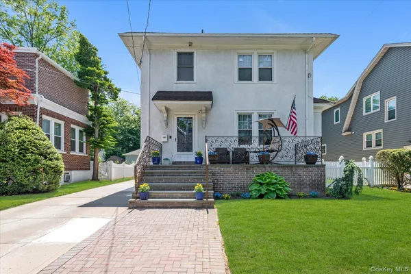 a front view of a house with garden and plants