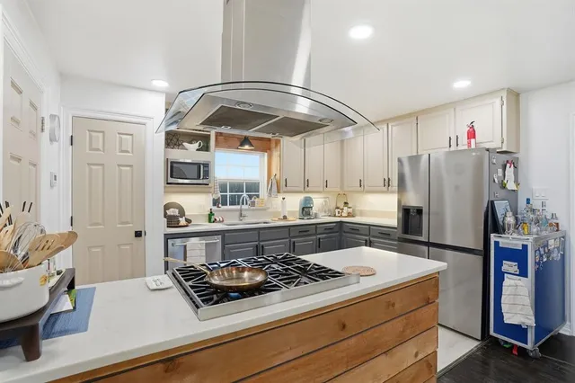 a kitchen with a stove a refrigerator and cabinets