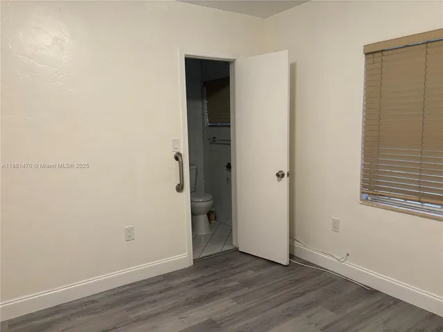 an empty room with wooden floor and closet