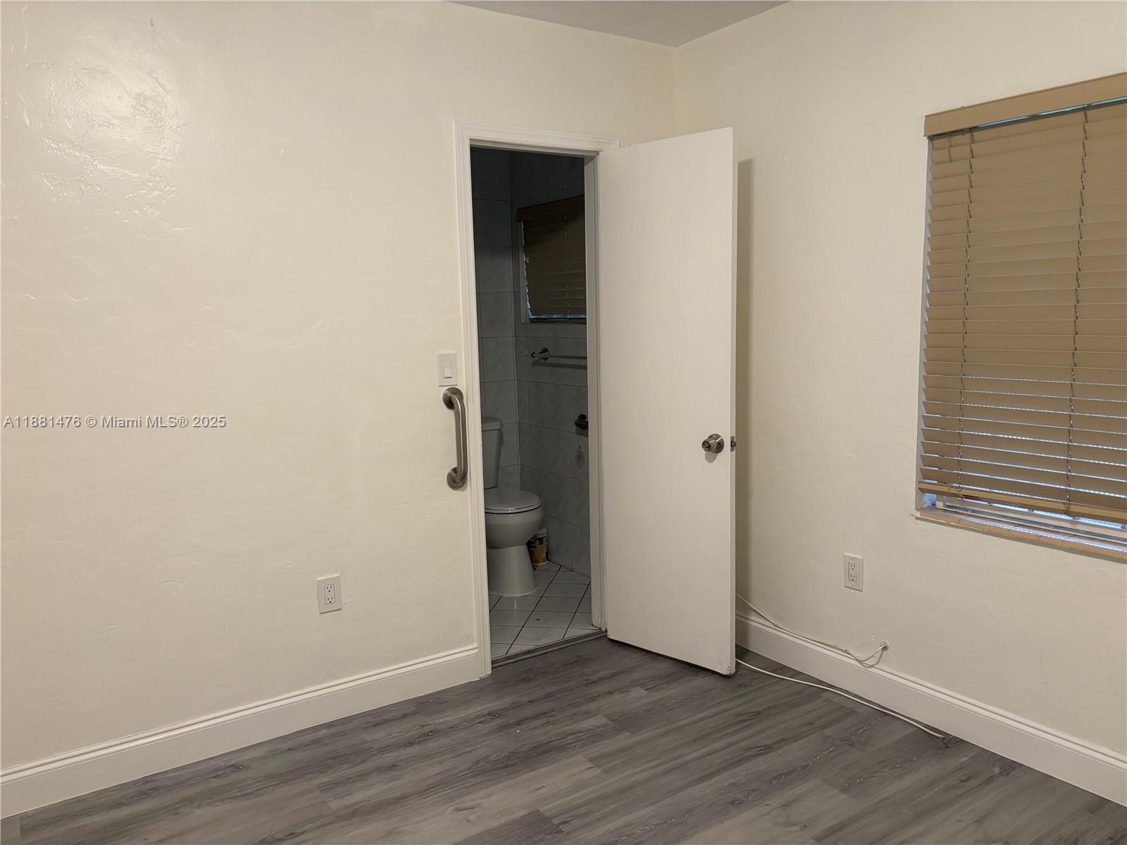 13041 Northwest 17th Court Miami, FL 33167 - Photo 13 of 23 an empty room with wooden floor and closet