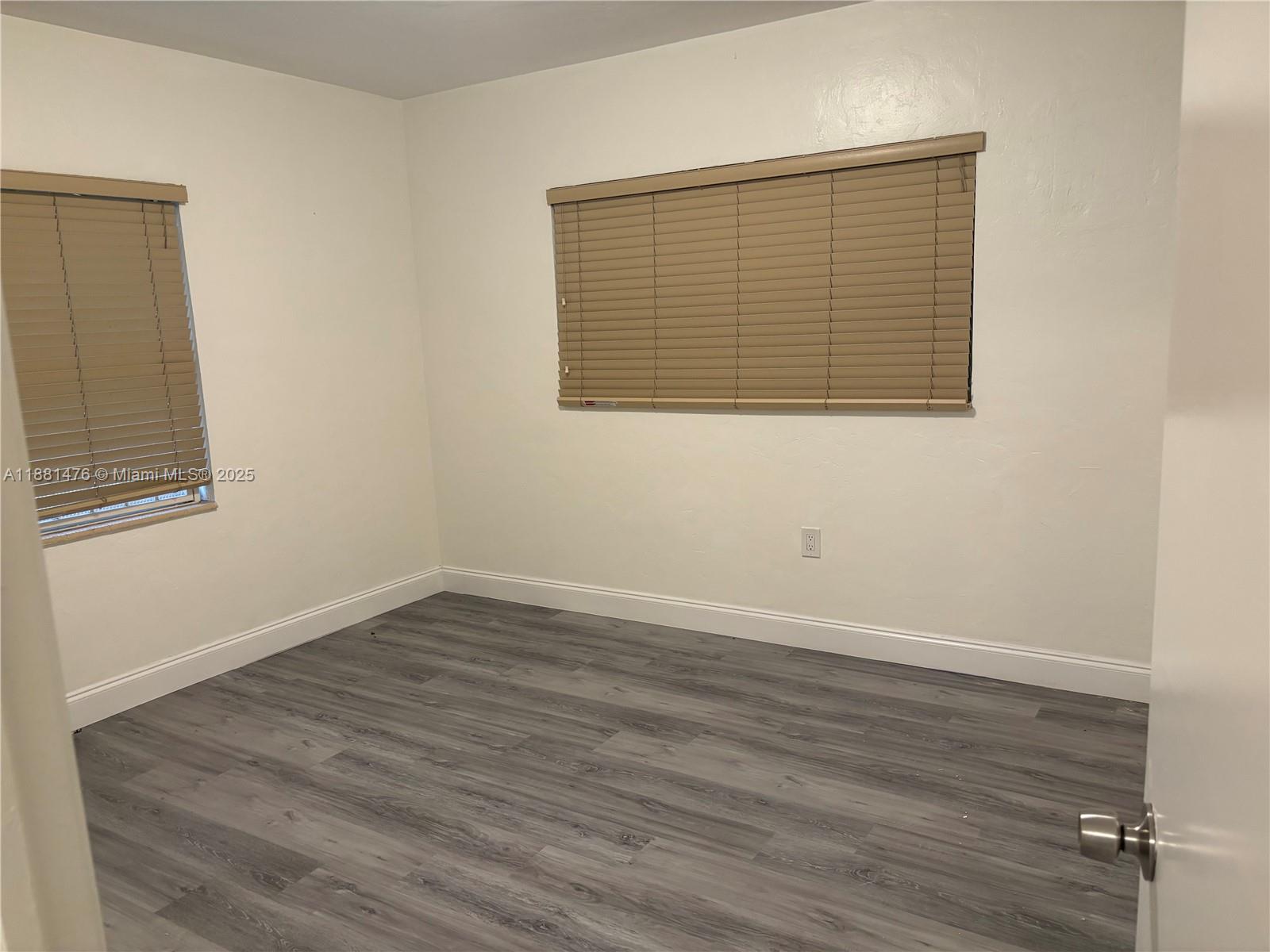 13041 Northwest 17th Court Miami, FL 33167 - Photo 14 of 23 a view of an empty room with wooden floor and a window
