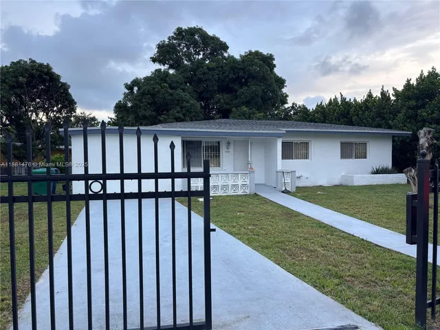 a view of a house with backyard and trees