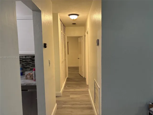 a view of a hallway with wooden floor