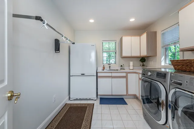 a kitchen with a refrigerator and white cabinets