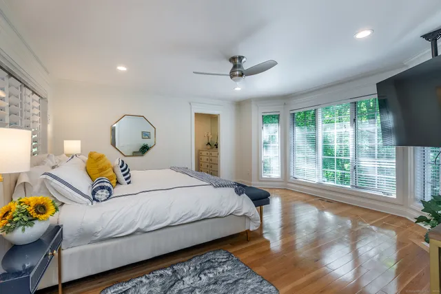 a bedroom with a bed mirror and window