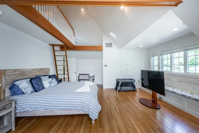 a bedroom with a bed and wooden floor