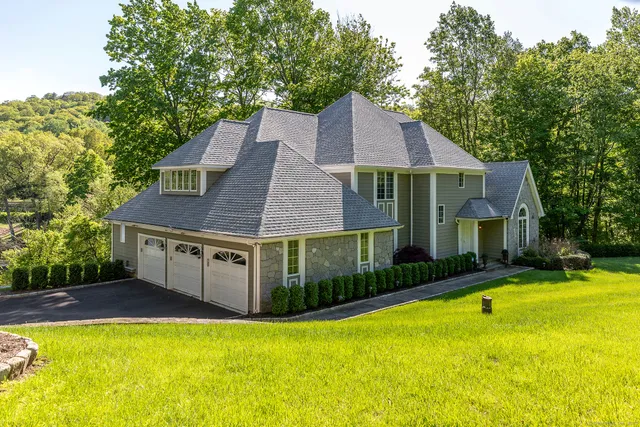 a front view of house with swimming pool and green space