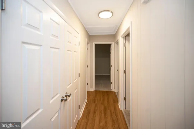 a view of a hallway with wooden floor and staircase