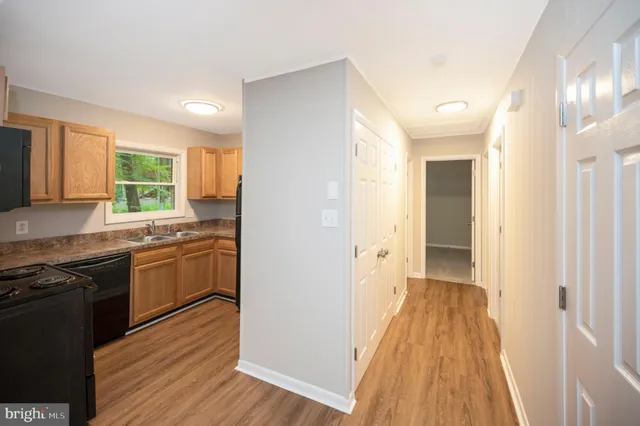 a kitchen with a sink and wooden floor
