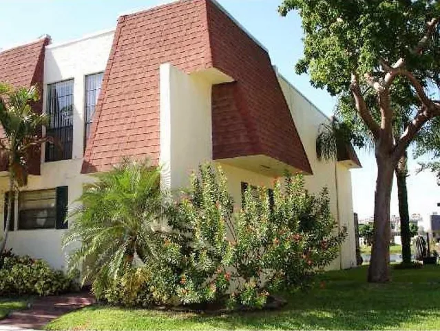 a view of a white house with a yard