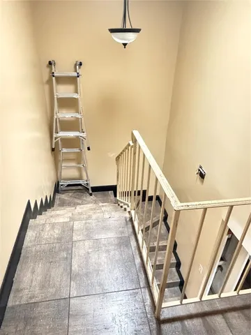 a view of a staircase with wooden floor and a rug
