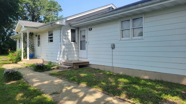 a view of a white house with a yard