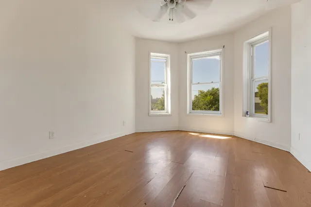 wooden floor in an empty room with a window