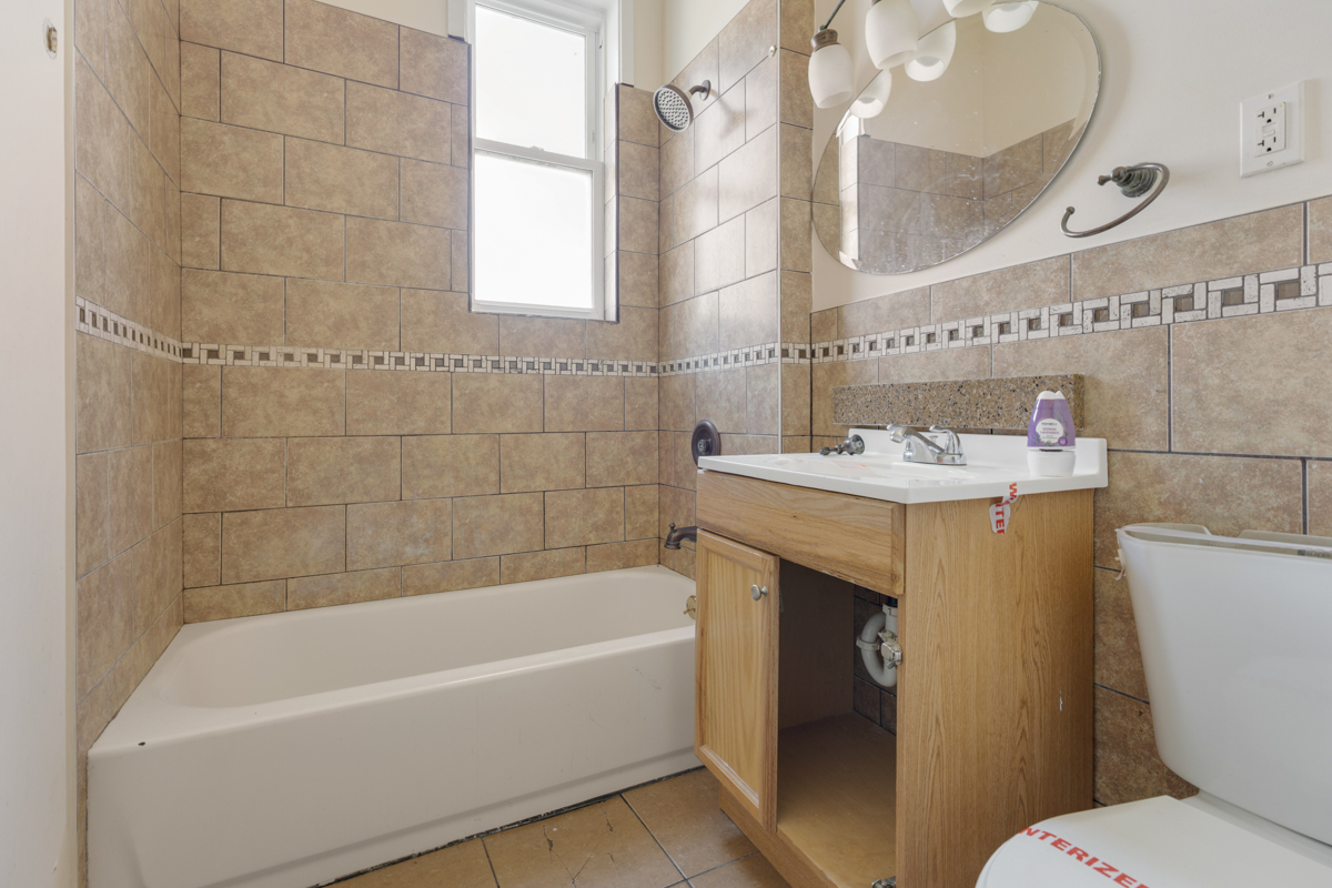 1141 South St Louis Avenue Chicago, IL 60624 - Photo 15 of 26 a bathroom with a sink a toilet a mirror and bathtub