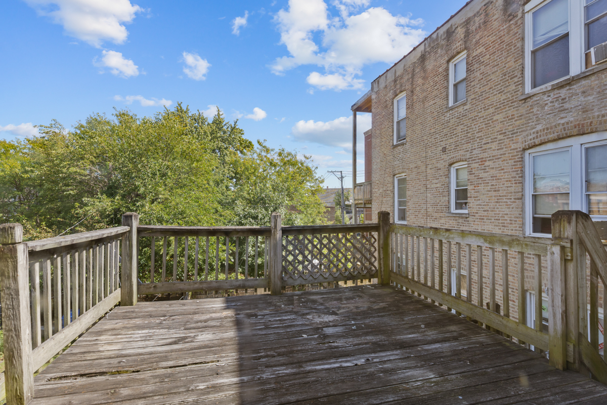 1141 South St Louis Avenue Chicago, IL 60624 - Photo 25 of 26 a balcony with wooden floor and fence