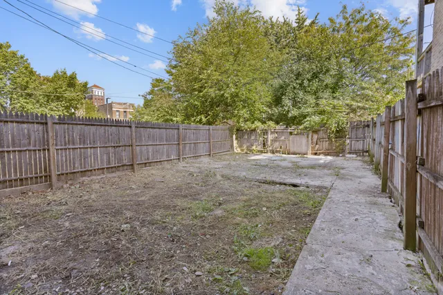 a view of a backyard with wooden fence