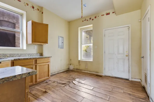 a bathroom with a granite countertop sink a mirror and a shower