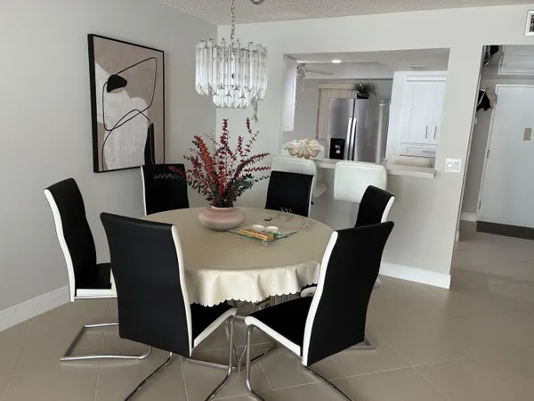 a view of a dining room with furniture a chandelier and wooden floor