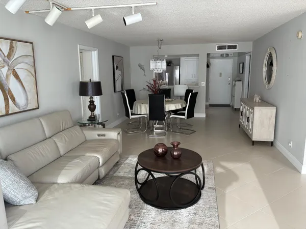 a living room with furniture a rug and a chandelier