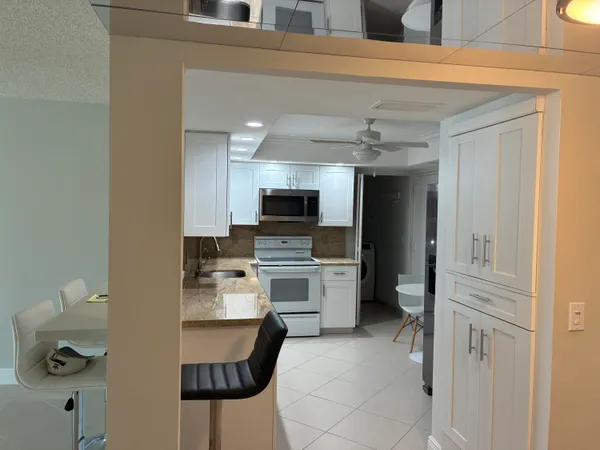 a kitchen with a refrigerator and a stove top oven