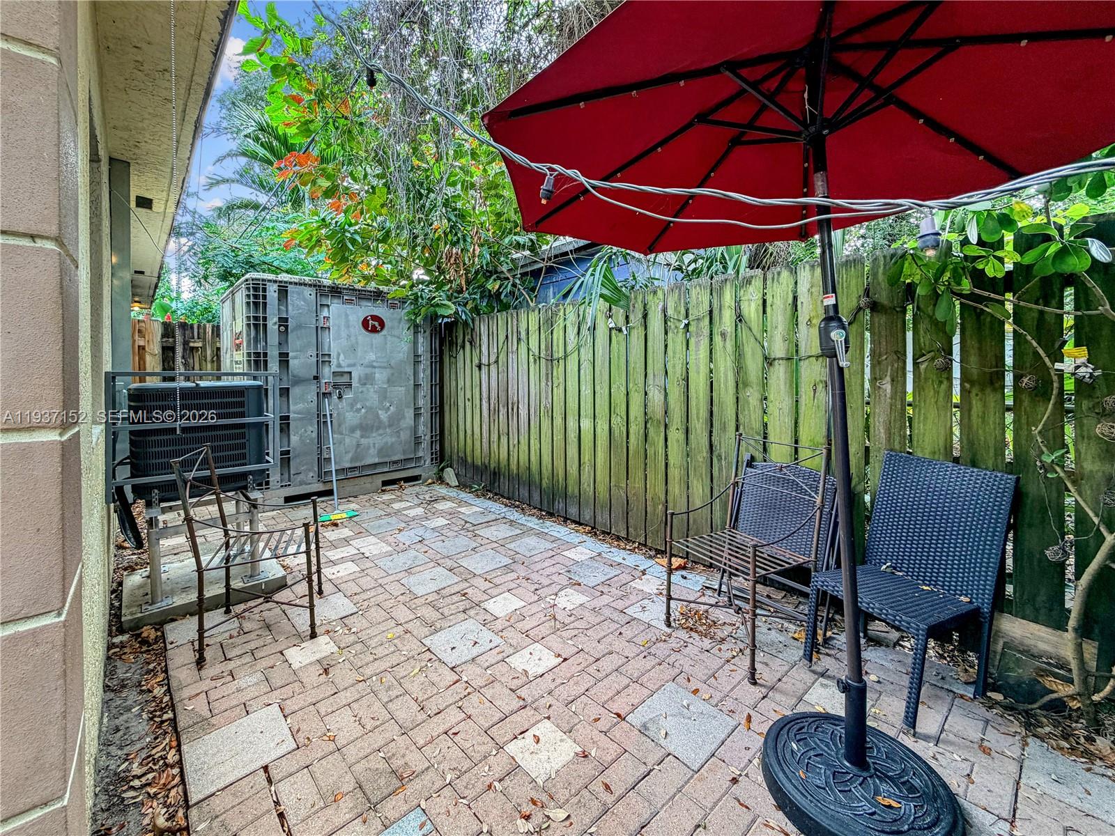 426 Northeast 77th Street, Unit 428 Miami, FL 33138 - Photo 13 of 22 a patio with table and chairs and potted plants