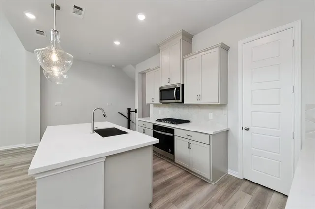 a kitchen with a sink a stove and cabinets